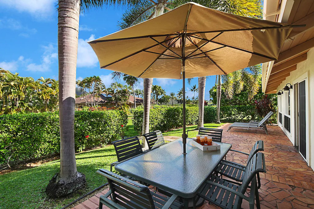 Hula Blue lanai dining with palms and garden views